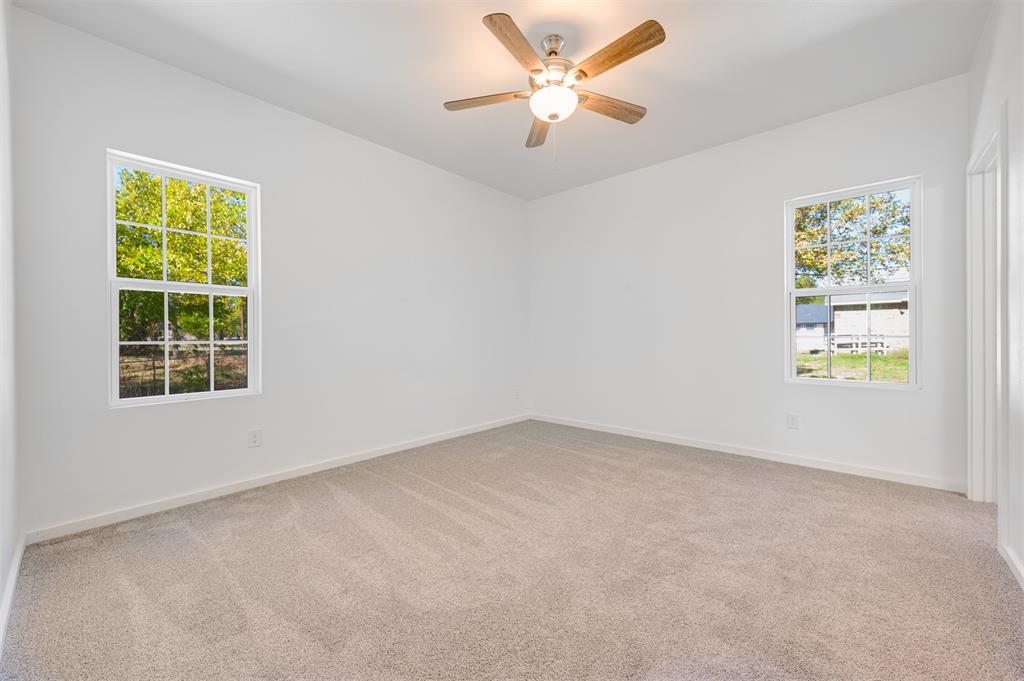 540 Southeast 2nd Street Cooper, TX 75432 - Photo 18 of 30 an empty room with windows and fan