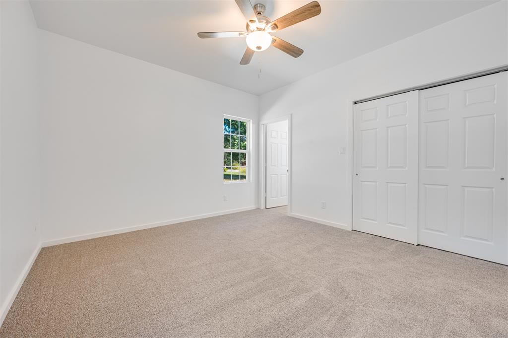 540 Southeast 2nd Street Cooper, TX 75432 - Photo 19 of 30 an empty room with windows and fan
