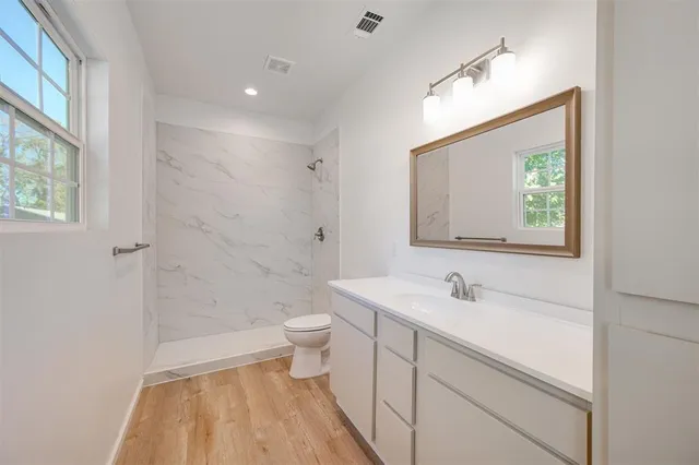 a bathroom with a sink a toilet and shower