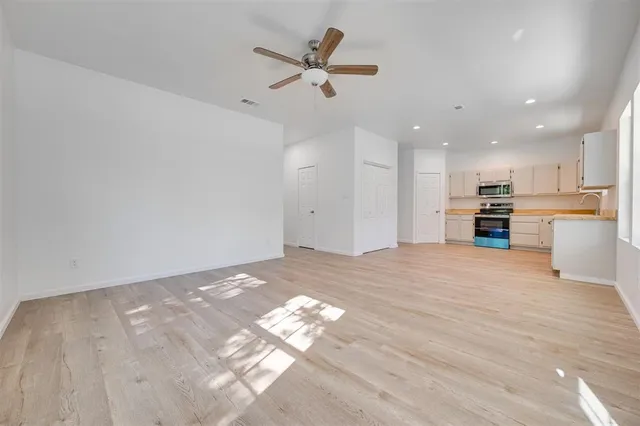 a view of an empty room with a kitchen