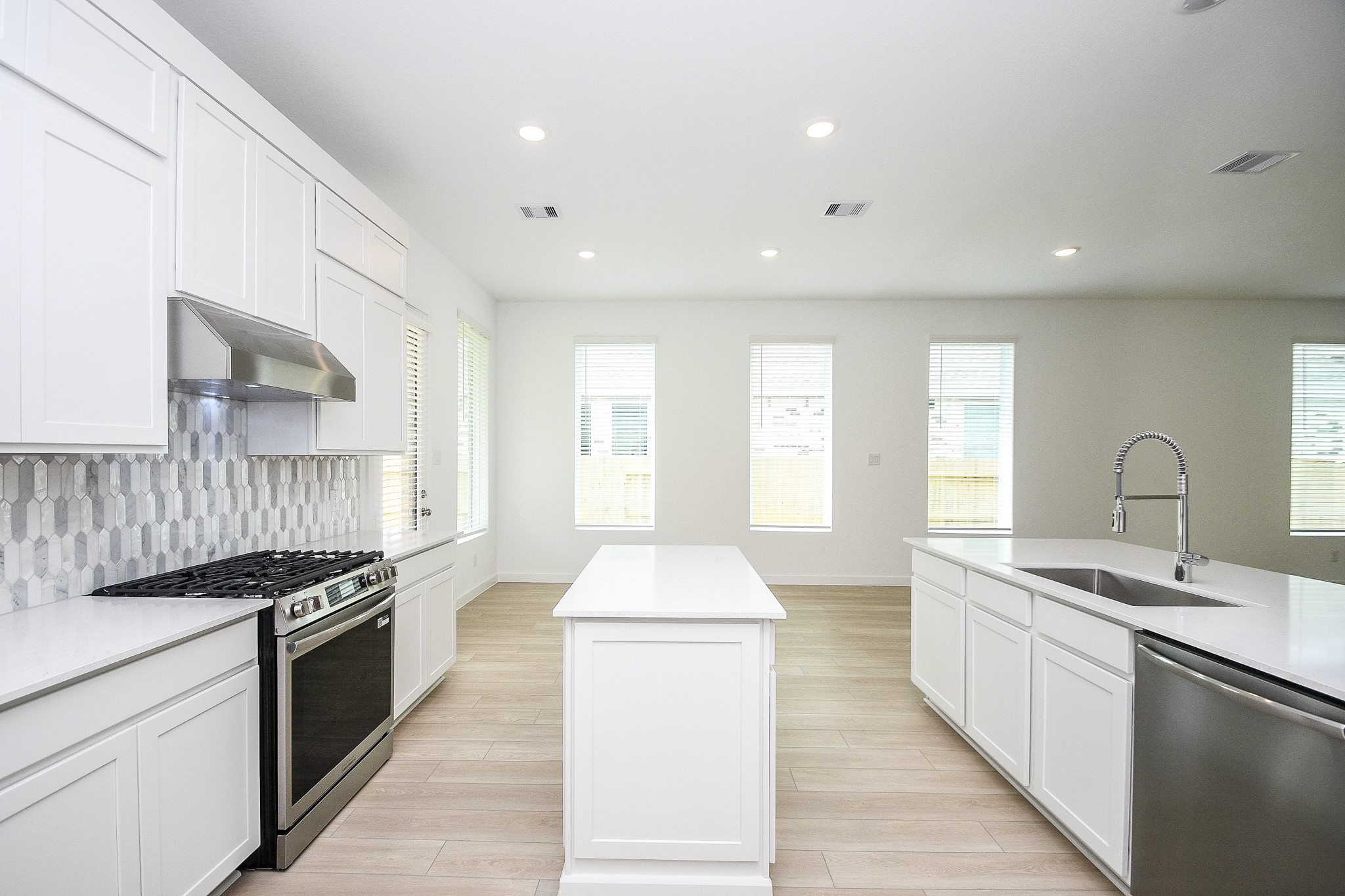 4227 Eagle Pass Drive Rosenberg, TX 77469 - Photo 2 of 28 a large kitchen with stainless steel appliances granite countertop a stove a sink and white cabinets