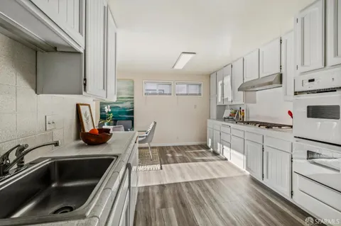 a kitchen with white cabinets and white appliances