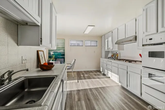 a kitchen with white cabinets and white appliances