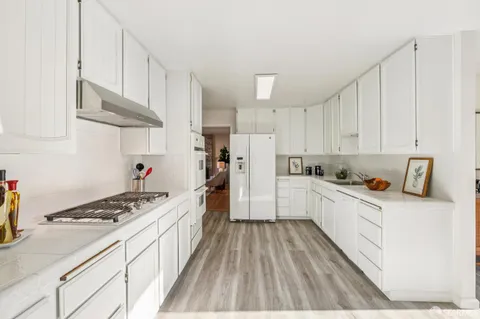 a kitchen with stainless steel appliances granite countertop a refrigerator and a stove top oven