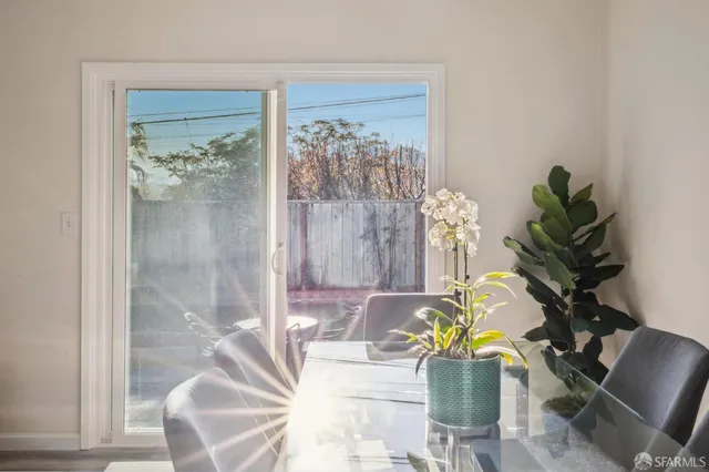 a table with chairs and a vase of flowers