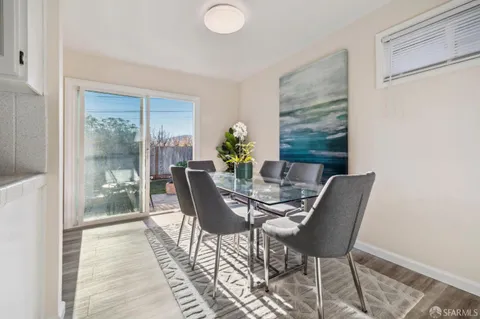 a view of a dining room with furniture a potted plant and wooden floor