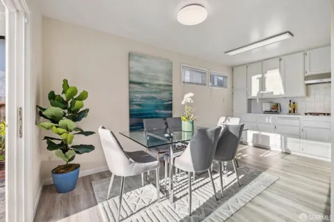 a kitchen with stainless steel appliances granite countertop a refrigerator a stove a sink dishwasher and white cabinets with wooden floor