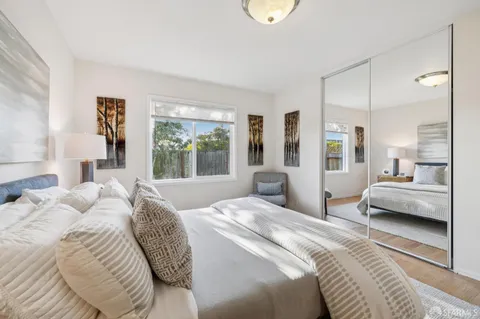 a bedroom with a bed couch and a potted plant