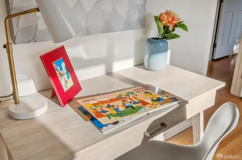 a bedroom with a bed and painting on the wall