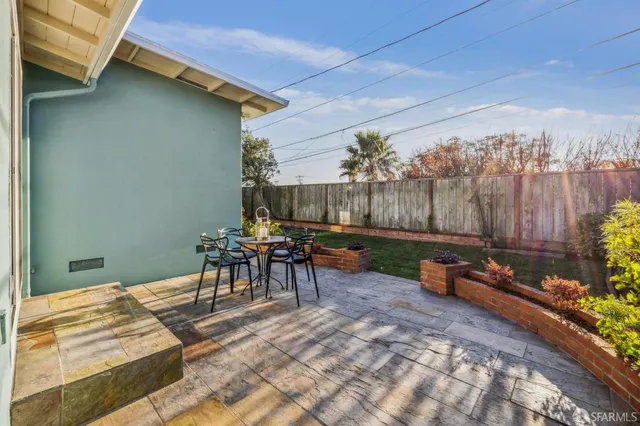 a backyard of a house with table and chairs
