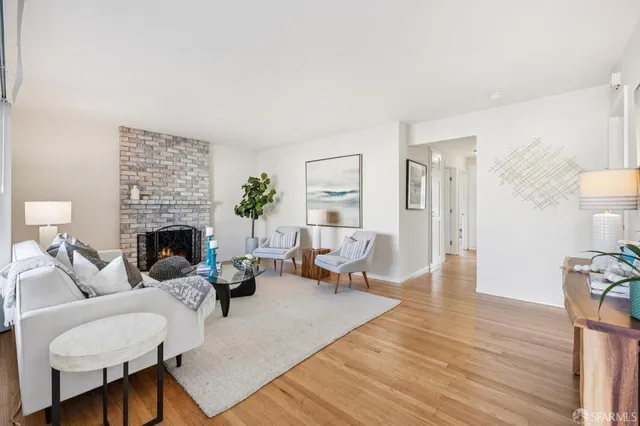 a living room with furniture a fireplace and a table with wooden floor