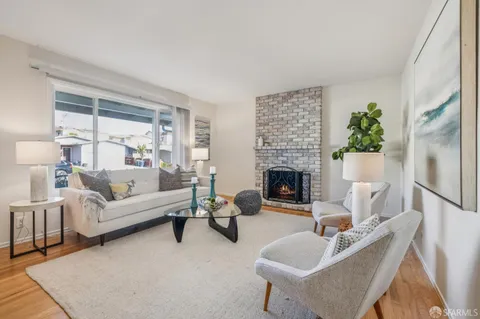 a living room with furniture lamp and kitchen view