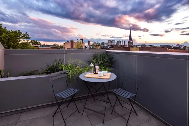a view of a balcony with chair and a barbeque