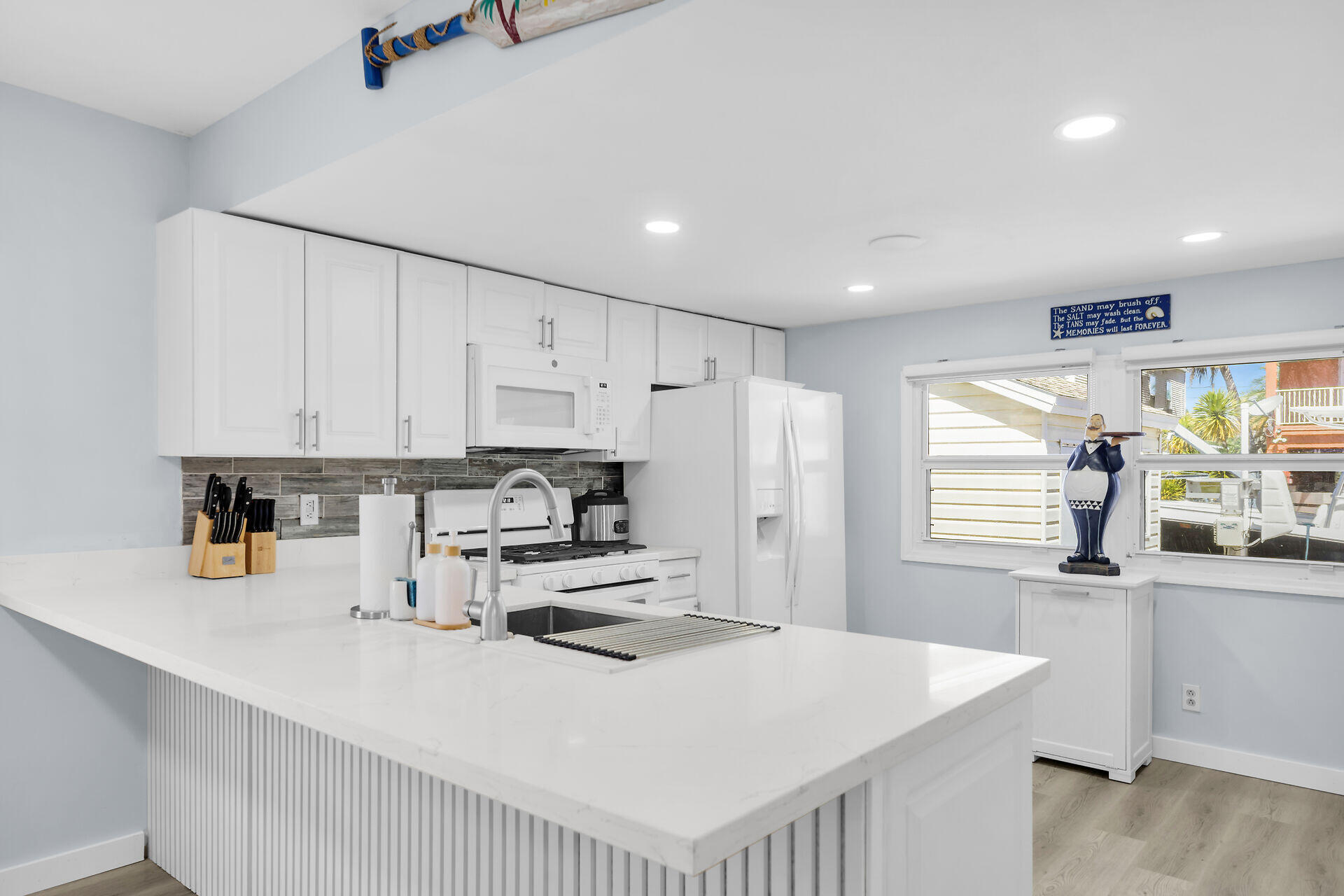 209 Buttonwood Avenue Key Largo, FL 33037 - Photo 16 of 46 a kitchen with kitchen island white cabinets and refrigerator