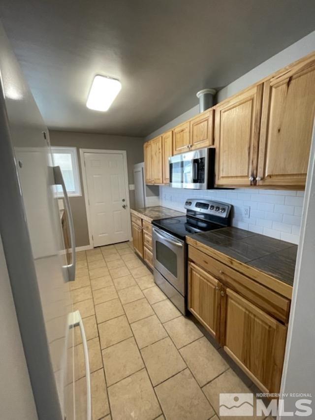 12192 Andes Street Reno, NV 89506 - Photo 8 of 17 a kitchen with stainless steel appliances a stove a sink and a microwave