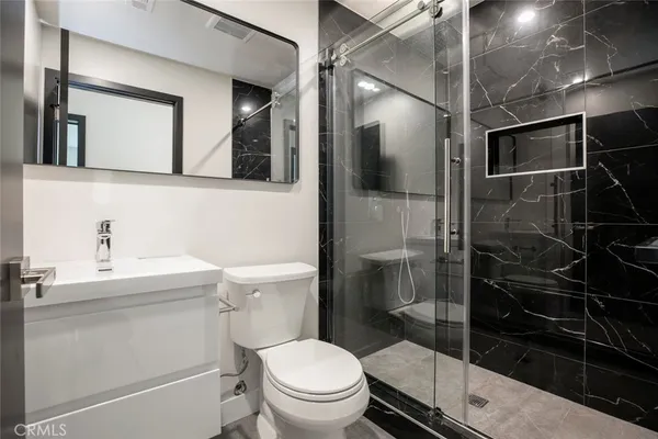 a bathroom with a toilet a sink and mirror
