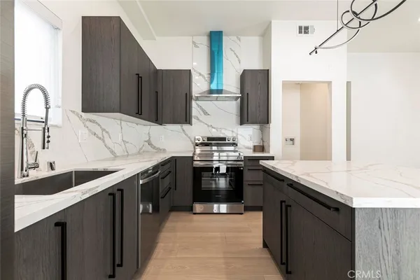 a kitchen with stainless steel appliances granite countertop a sink stove and refrigerator
