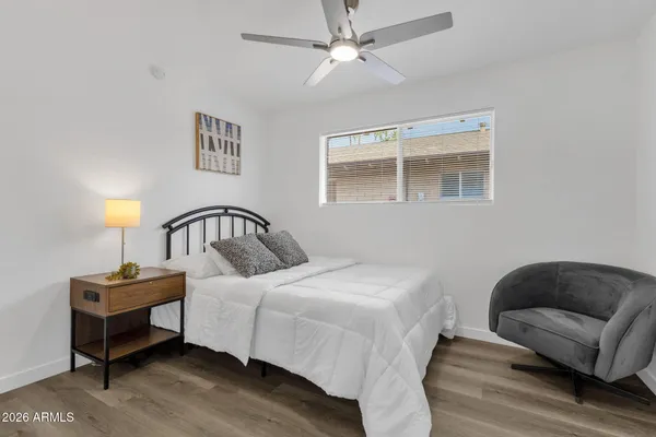 a bedroom with a bed a lamp and a potted plant