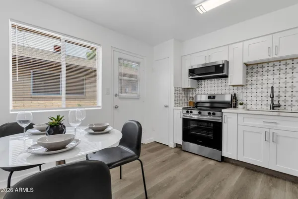 a kitchen with stainless steel appliances a stove a sink a microwave a refrigerator and cabinets