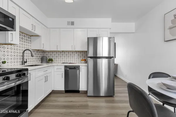 a kitchen with appliances a sink and cabinets