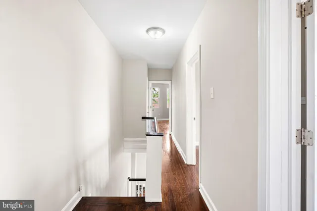 a view of a hallway with wooden floor and staircase