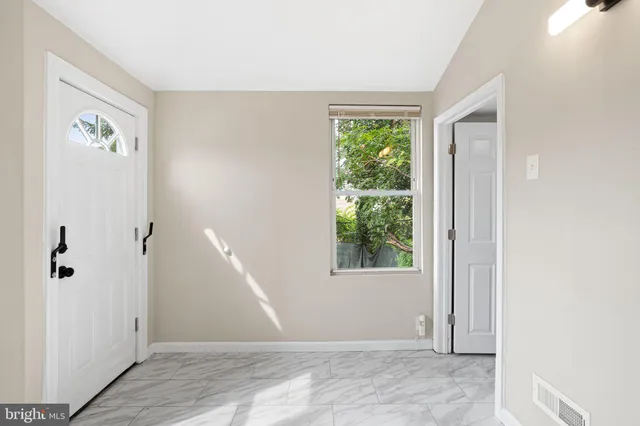 a view of an empty room with window and closet area