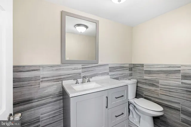 a bathroom with a granite countertop toilet sink and mirror