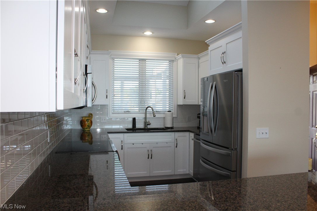 122 Turtle Bay Huron, OH 44839 - Photo 4 of 31 Kitchen with sink, white cabinetry, and tasteful backsplash