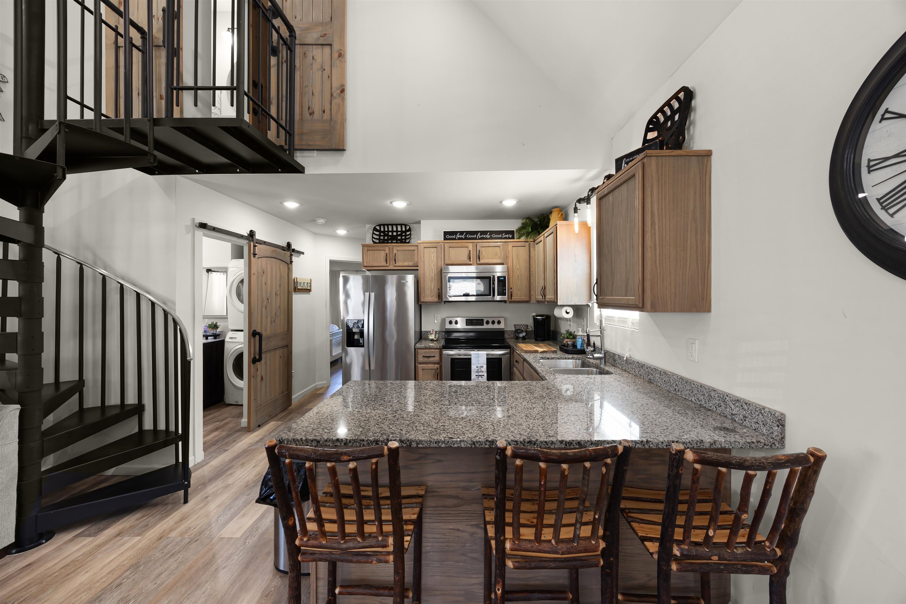 15 Bogey Loop Counce, TN 38326 - Photo 10 of 17 Kitchen featuring stainless steel appliances, a barn door, light wood finished floors, stone countertops, and a peninsula
