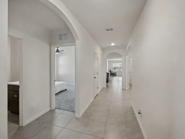 a view of a hallway with a livingroom and a bathroom