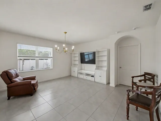 a living room with furniture a flat screen tv and a window