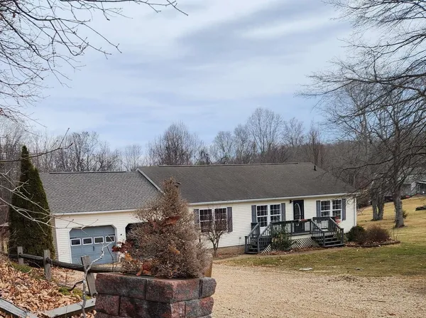 a front view of house with yard covered in snow