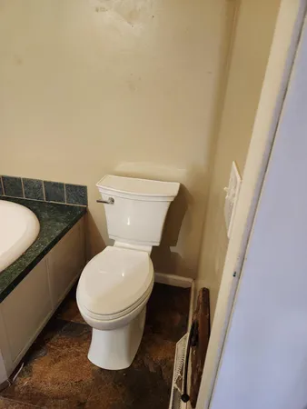 a white toilet sitting next to a small bathroom