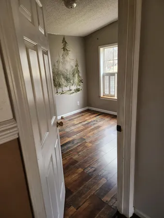 a view of a room with wooden floor and windows