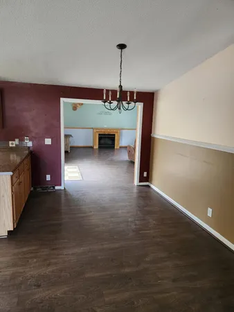 a view of a room with wooden floor and ceiling fan