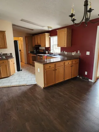a kitchen with stainless steel appliances granite countertop a sink stove and wooden cabinets