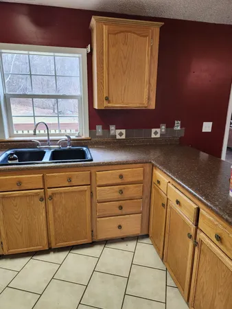 a kitchen with granite countertop white cabinets and white appliances