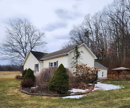 a front view of house with yard and trees around