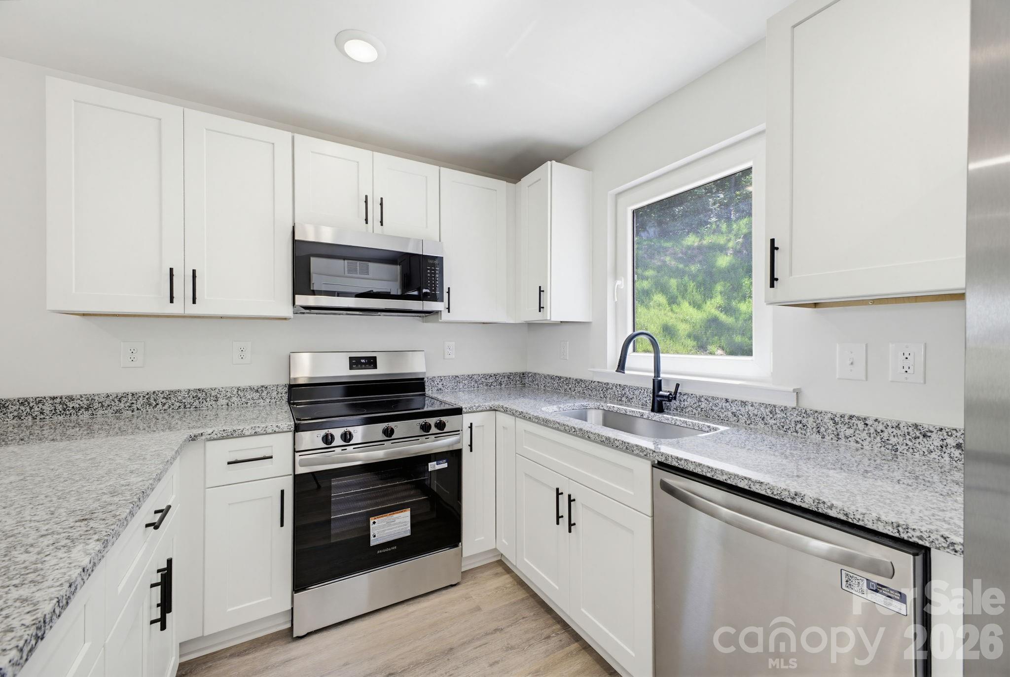 701 2nd St Place Southwest Conover, NC 28613 - Photo 11 of 16 a kitchen with granite countertop a sink a stove and cabinets