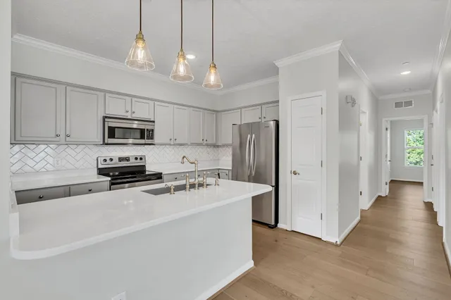 a kitchen with stainless steel appliances granite countertop a refrigerator a stove a sink and a center island