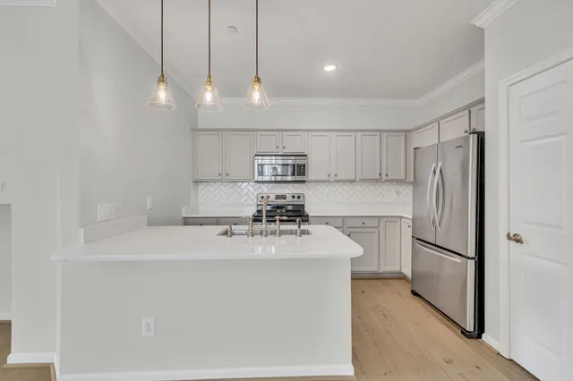a kitchen with kitchen island a sink stainless steel appliances and cabinets