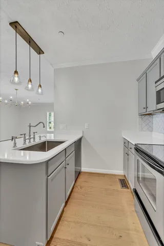 a kitchen with kitchen island granite countertop a sink stainless steel appliances and cabinets