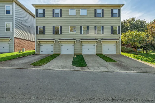 a front view of a house with a yard and a garage