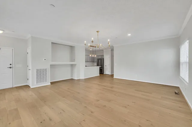 wooden floor in an empty room with a kitchen