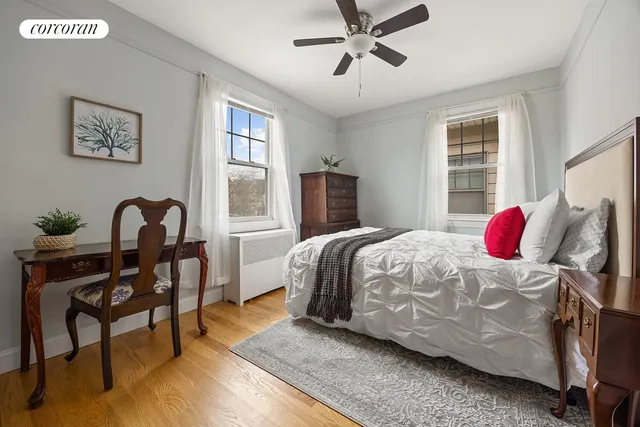 a bedroom with a bed wooden floor and window