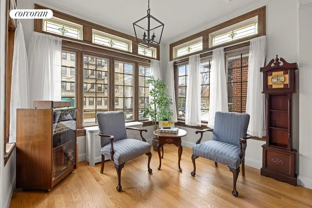 a living room with furniture a rug potted plant and a large window