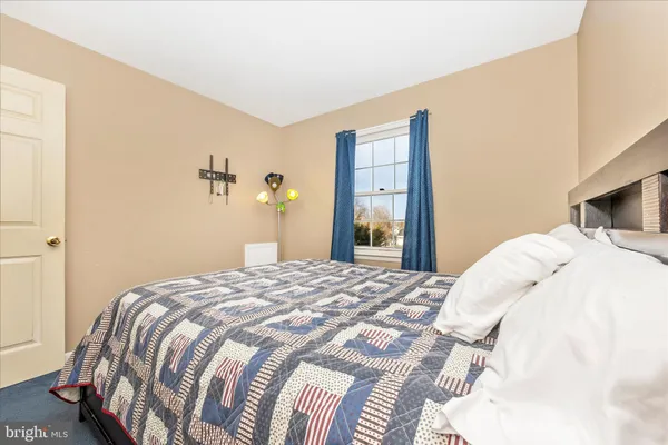 a bedroom with a bed and a painting on the wall