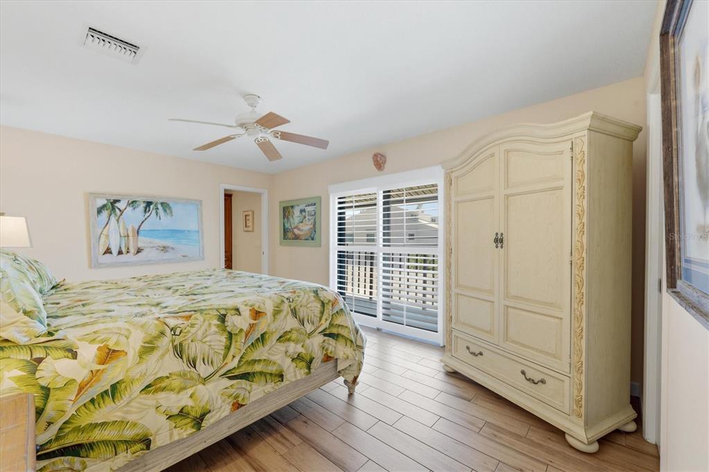 2729 North Beach Road, Unit 211 Englewood, FL 34223 - Photo 23 of 51 a spacious bedroom with a bed and a chandelier
