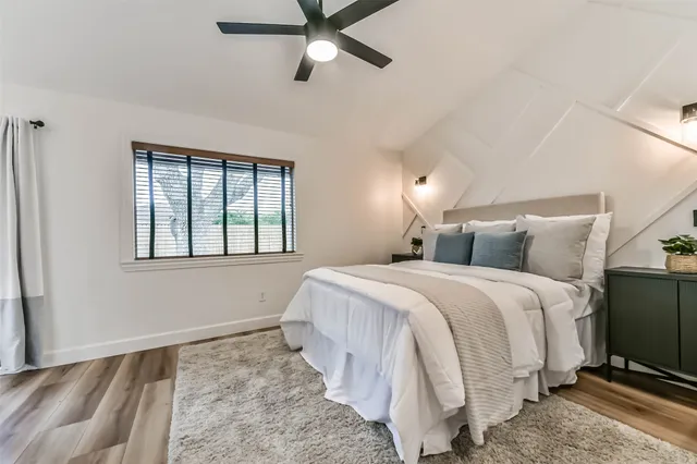 a bedroom with a large bed and a chandelier