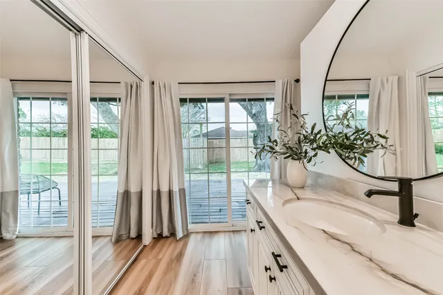 a bathroom with a glass shower door and a window